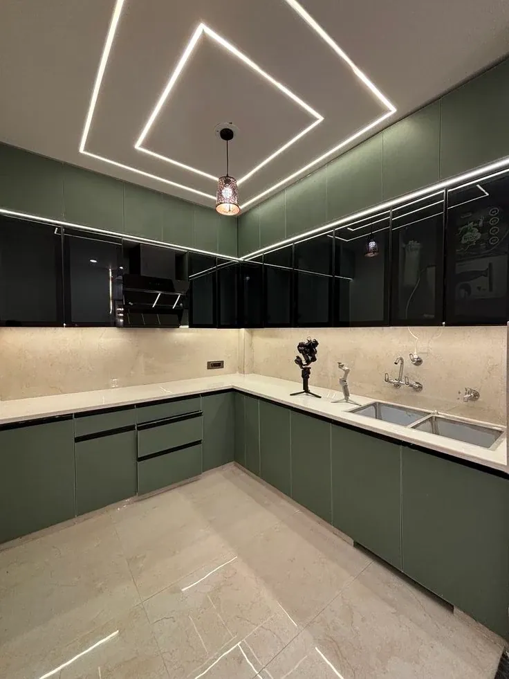Completed kitchen with olive-green base units, pale stone counter and black glass wall cabinets edged with light
